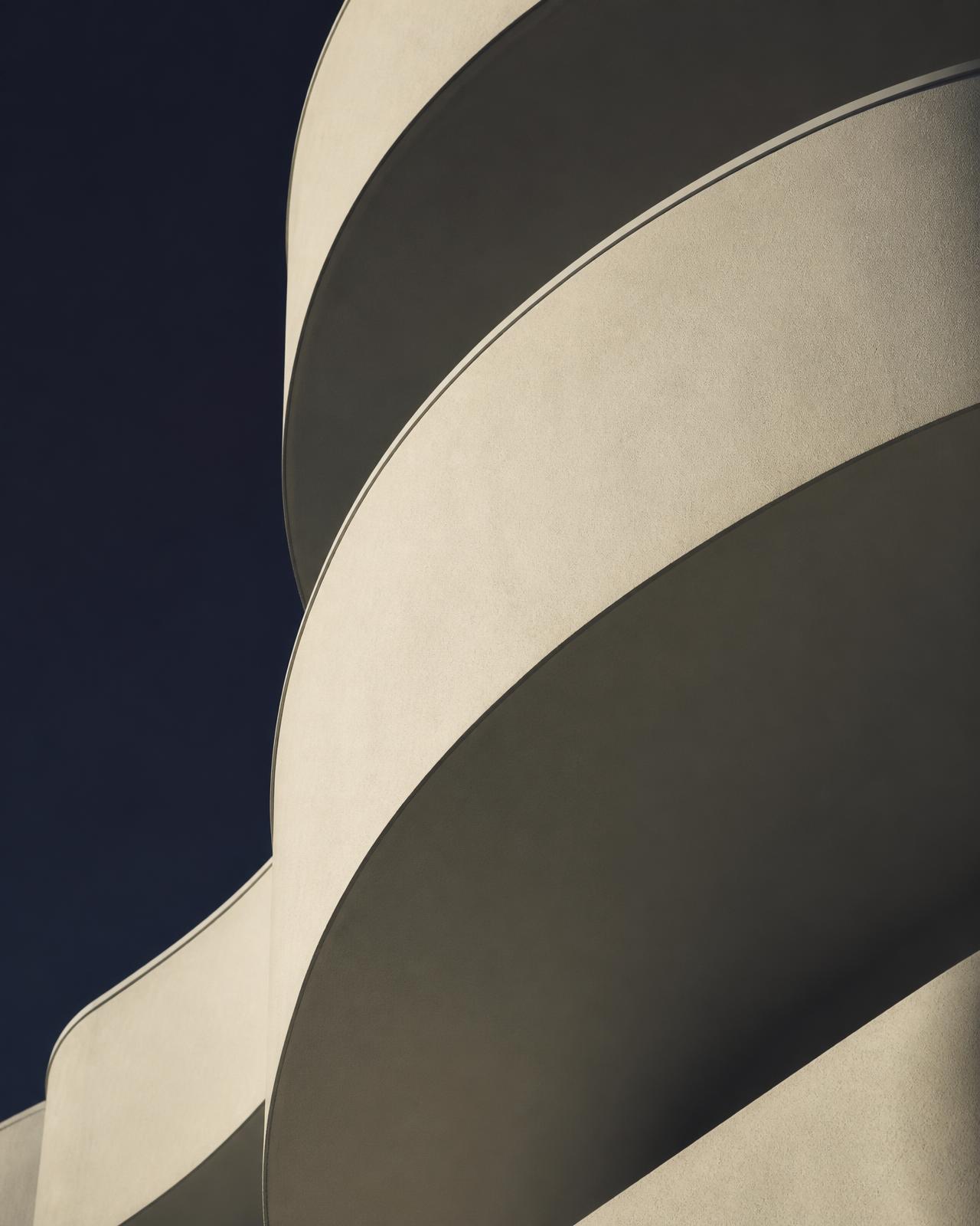 Curved architectural balcony edges against a deep navy sky